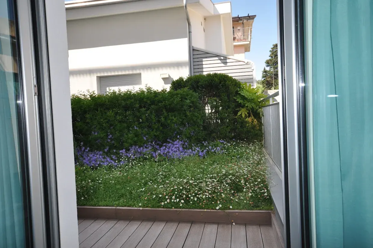 La porta finestra di una camera Garden aperta sul giardino fiorito