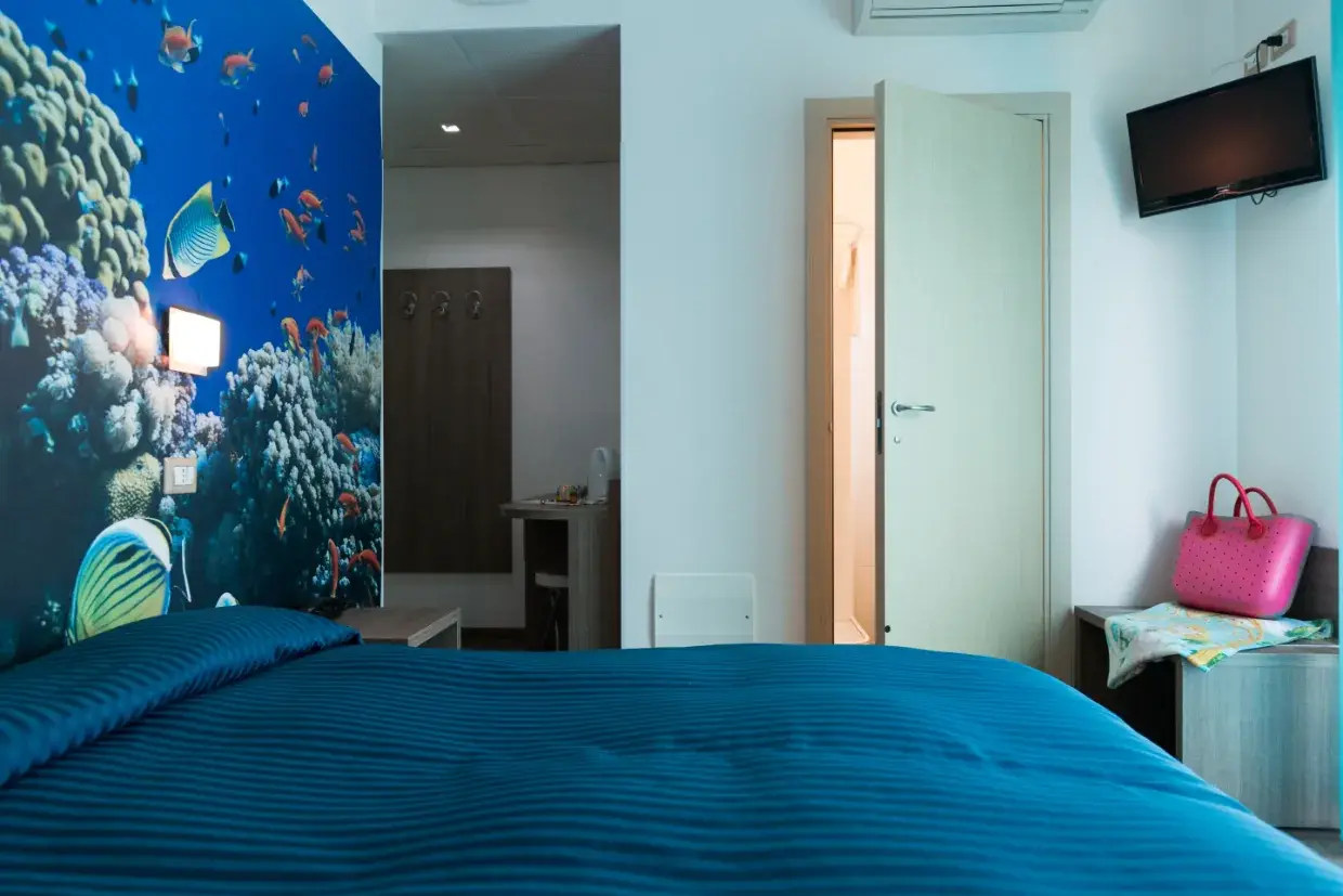 Camera doppia superior del Miramare Hotel di Pineto con letto matrimoniale e parete decorata a tema marino