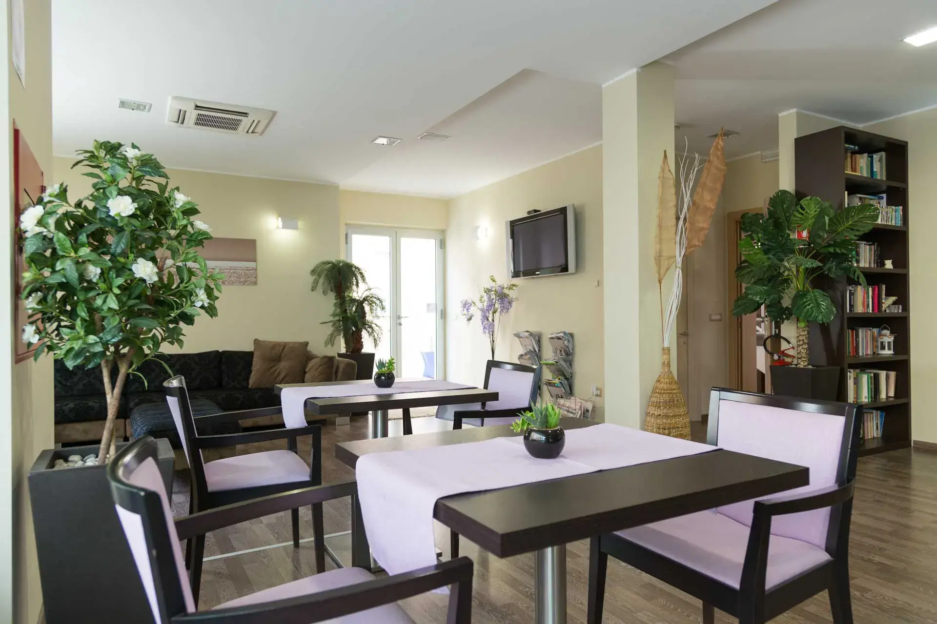 La sala comune del Miramare Hotel di Pineto, con tavoli e libreria
