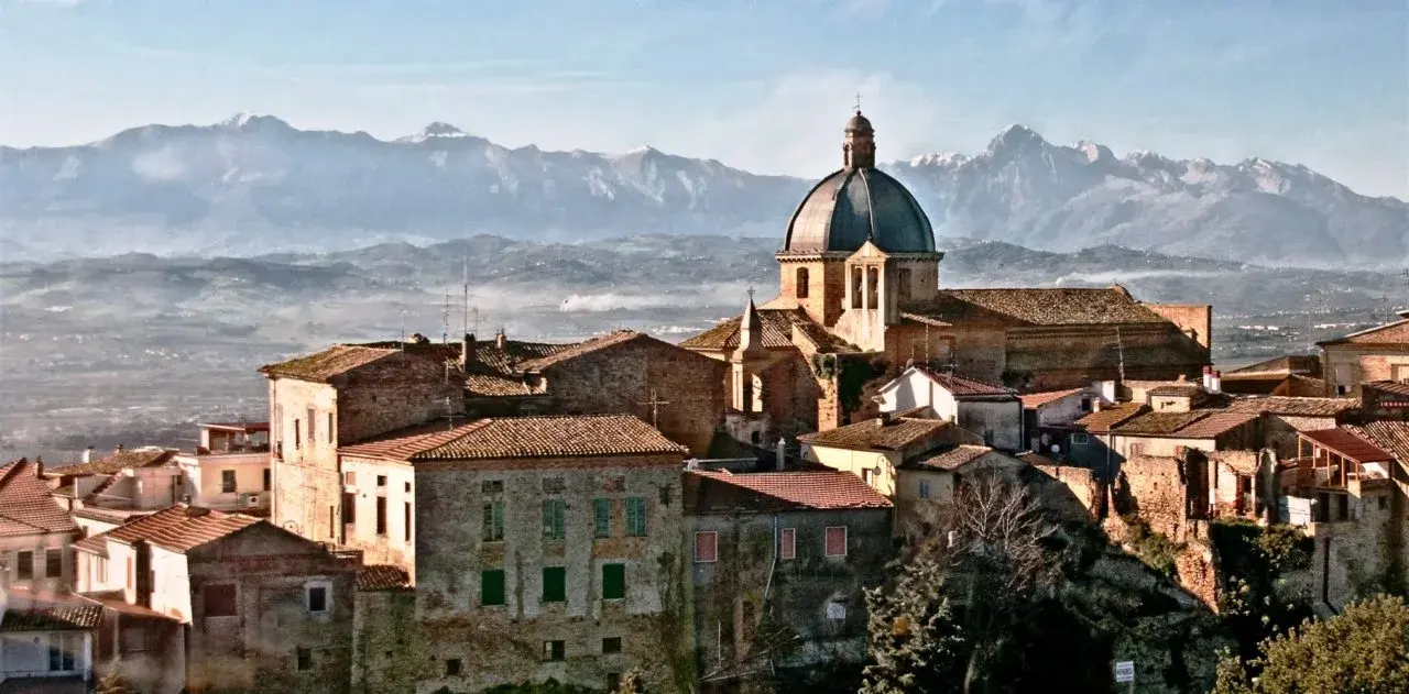 Il borgo di Montepagano con la cupola della chiesa e le montagne innevate all’orizzonte
