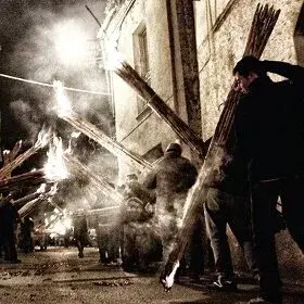 Uomini che portano in spalla i faugni accesi, di notte, nelle vie di Atri