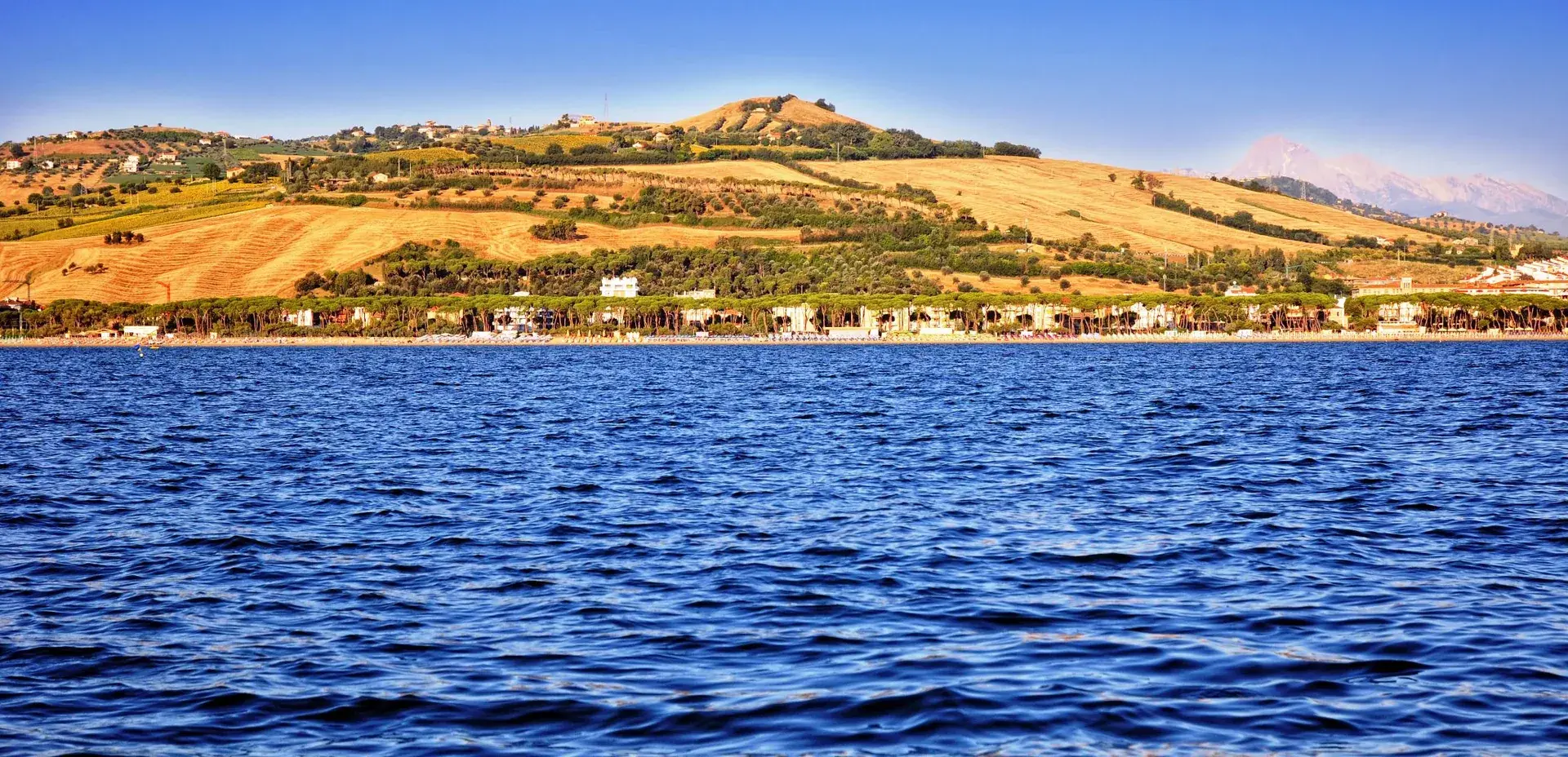 La costa di Pineto vista dal mare, con le colline dorate alle spalle