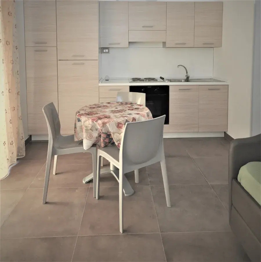 Il tavolo e la cucina di un bilocale del Miramare Residence a Pineto