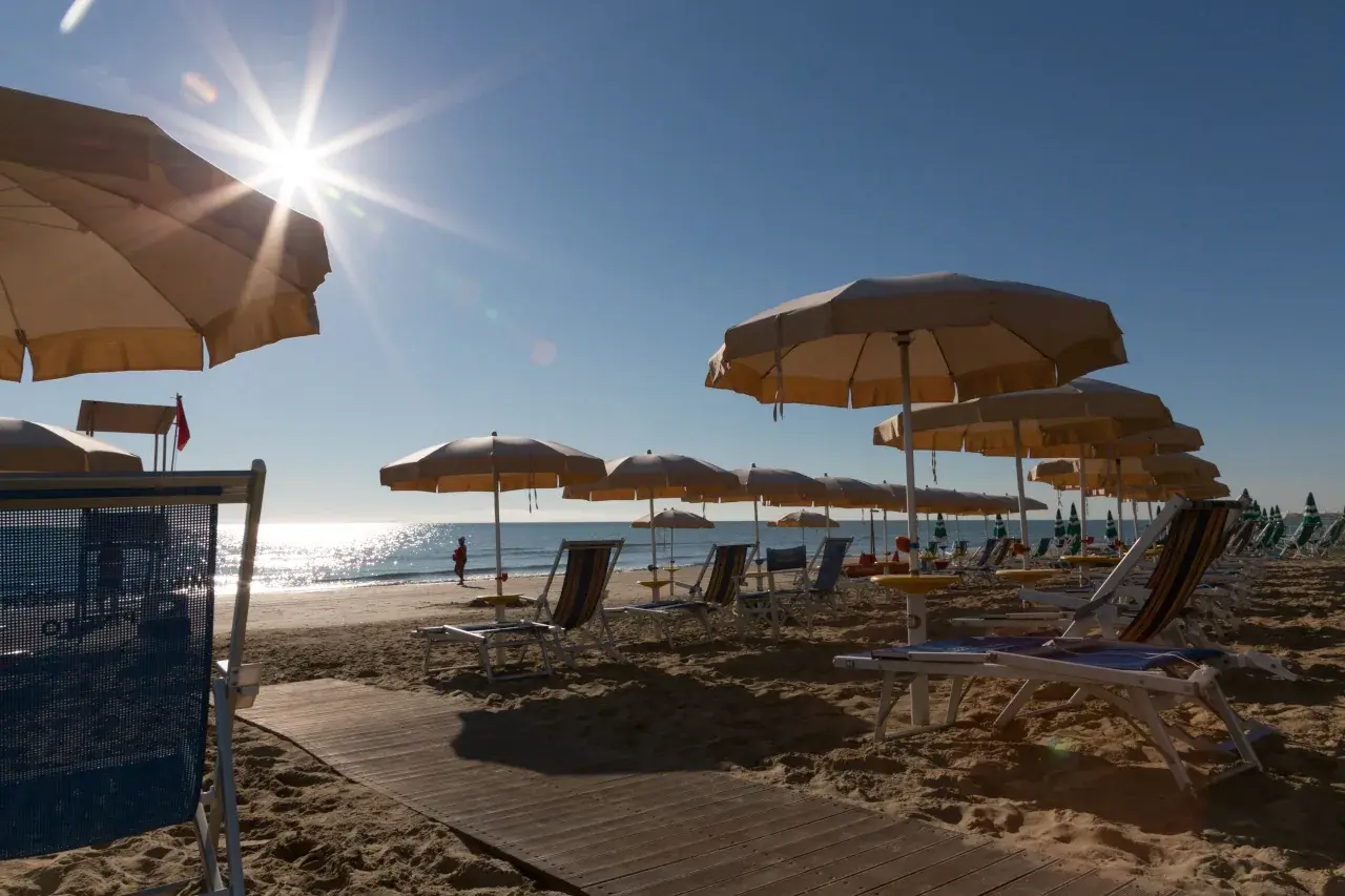 File di ombrelloni e lettini del Lido Miramare Corfù sulla spiaggia di sabbia dorata di Pineto